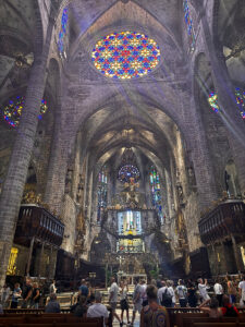 Close-up view of the altar area of the Palma Cathedral with the forged iron baldachin over the altar and numerous stained-glass windows.